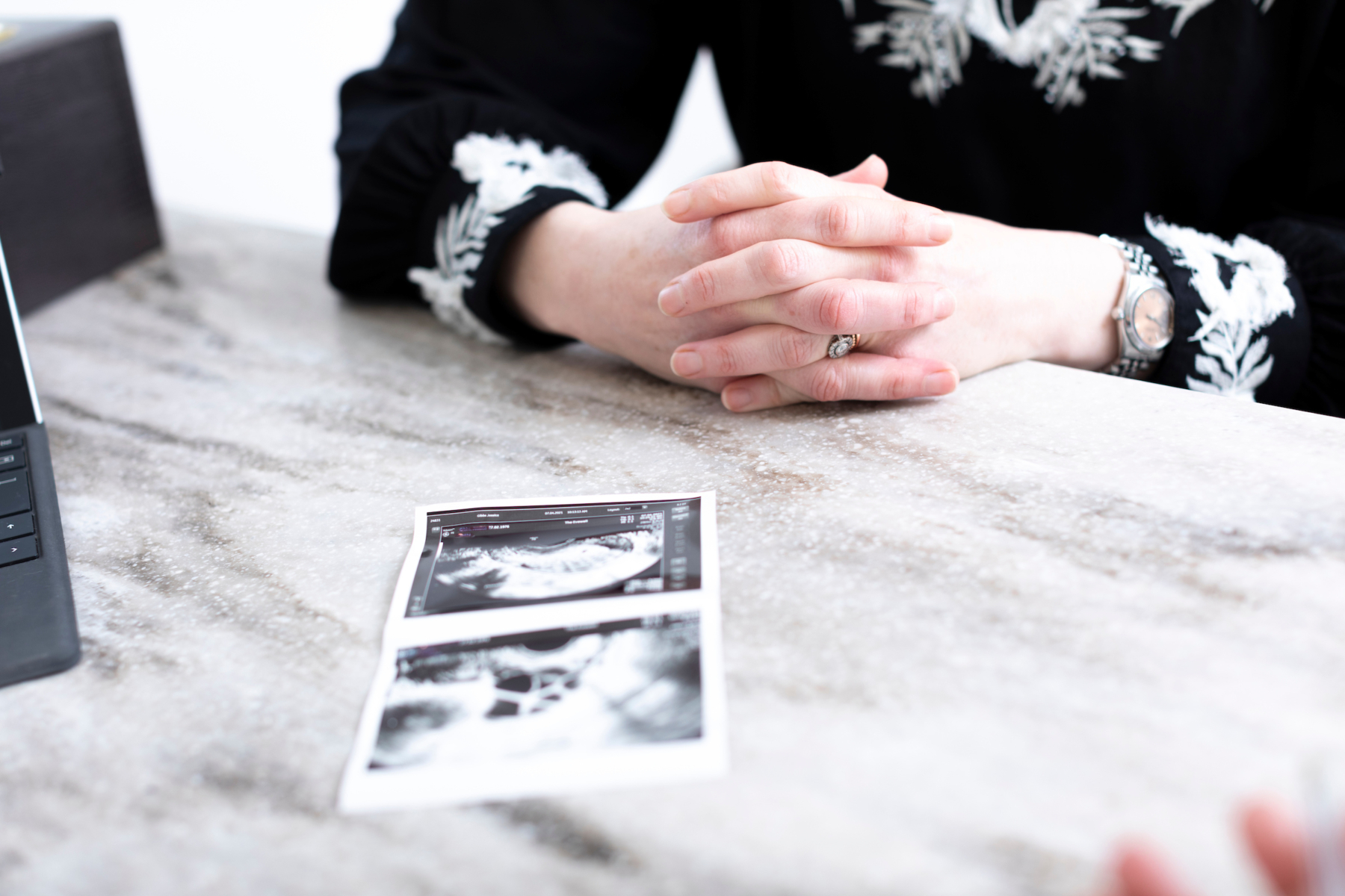 Patient with her ultrasound pictures in front of her on a desk