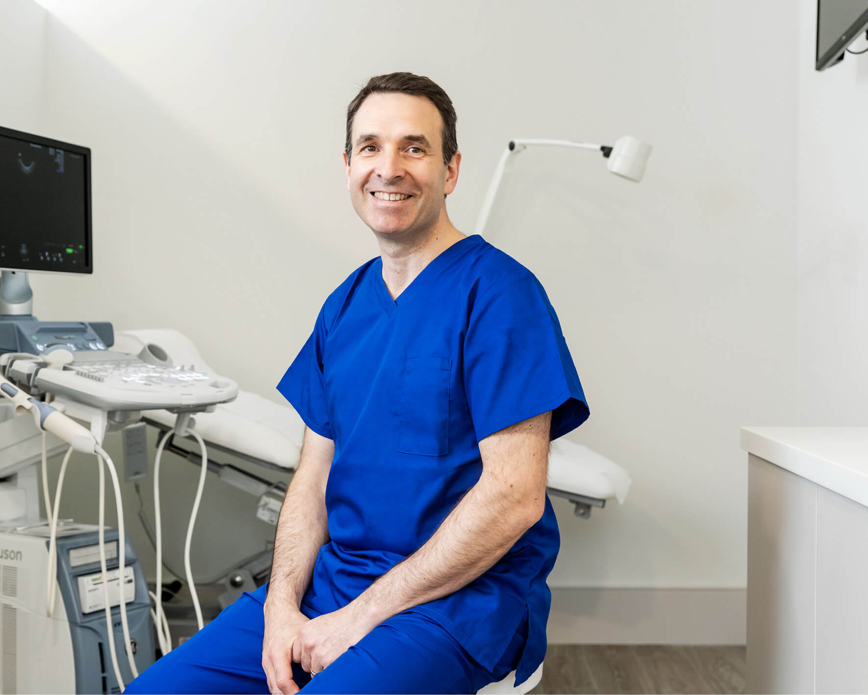 Colin Davis fertility consultant sitting in scrubs in the Evewell laboratory