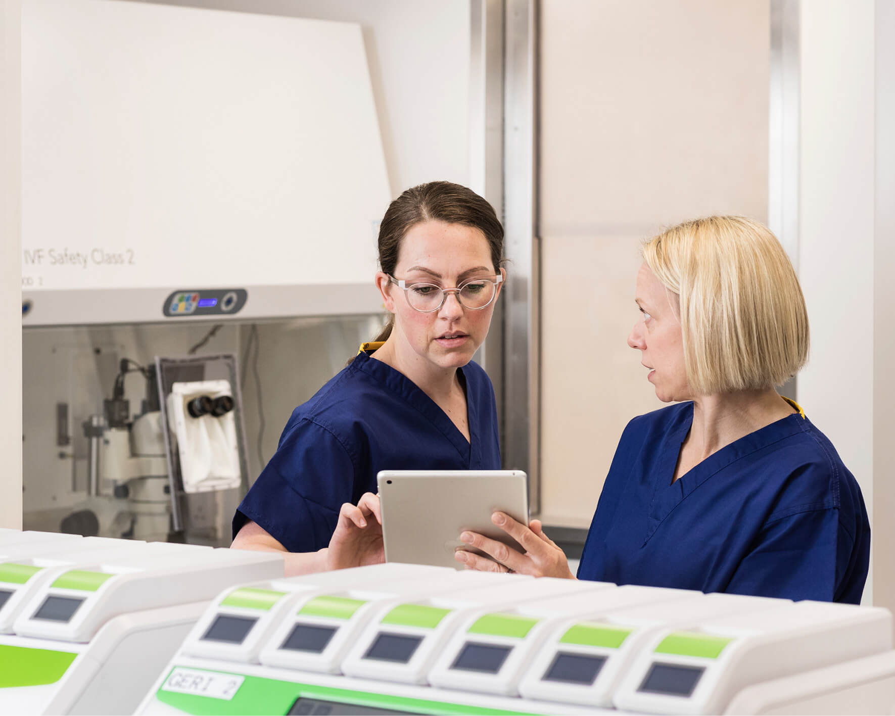 Two embryologists in the laboratory discussing samples on an ipad