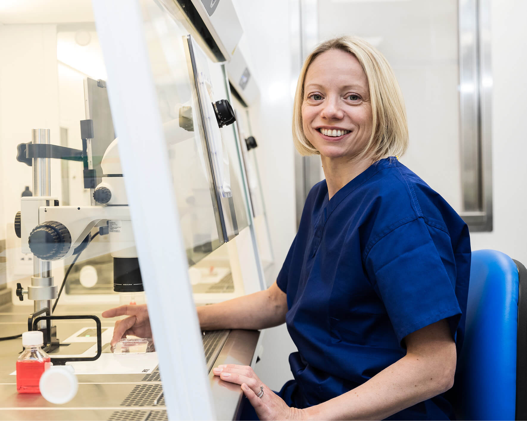 Embryologist sitting in her lab looking at fertility samples and embryo freezing