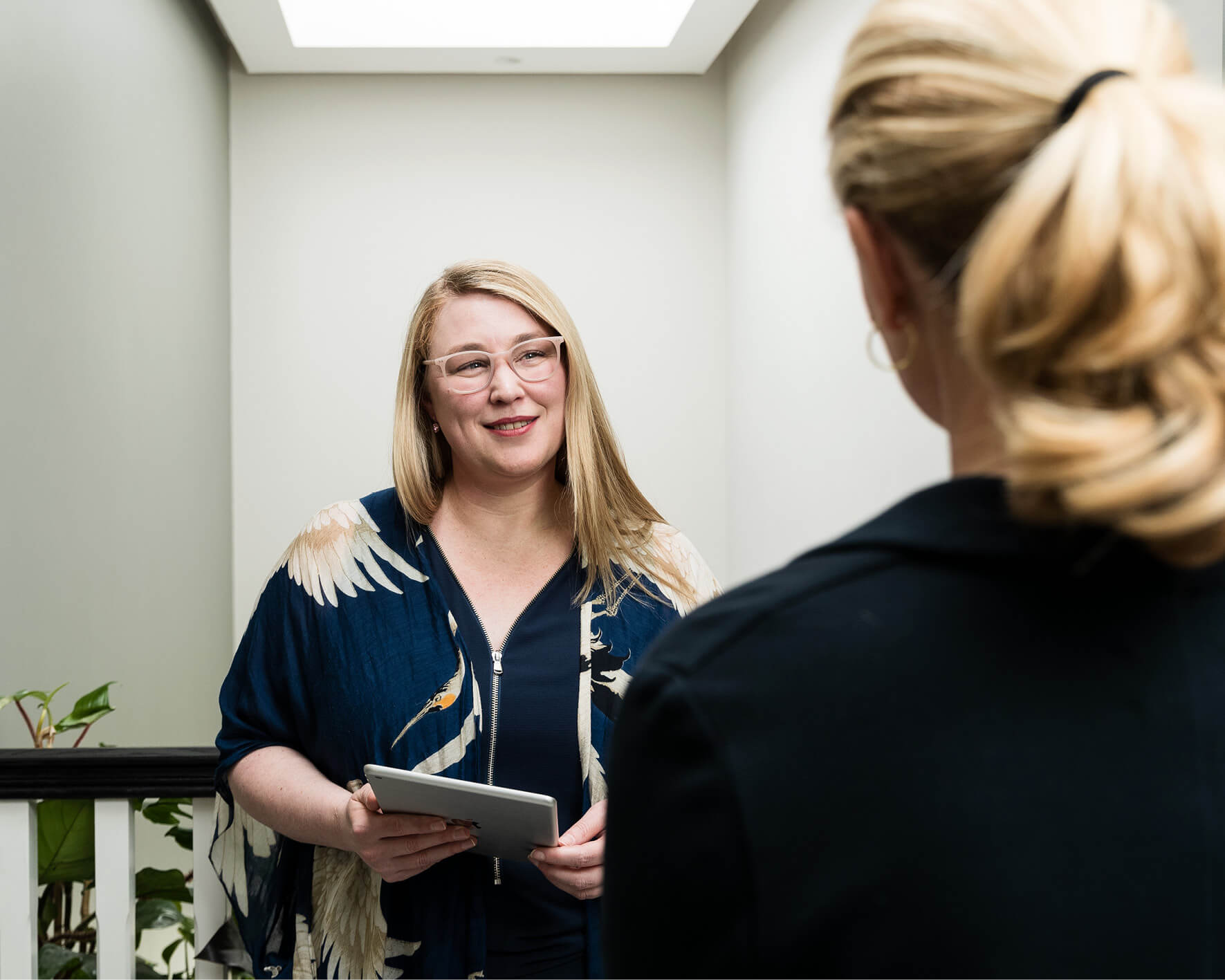 Image of a consultant talking to another woman in a hallway about infertility