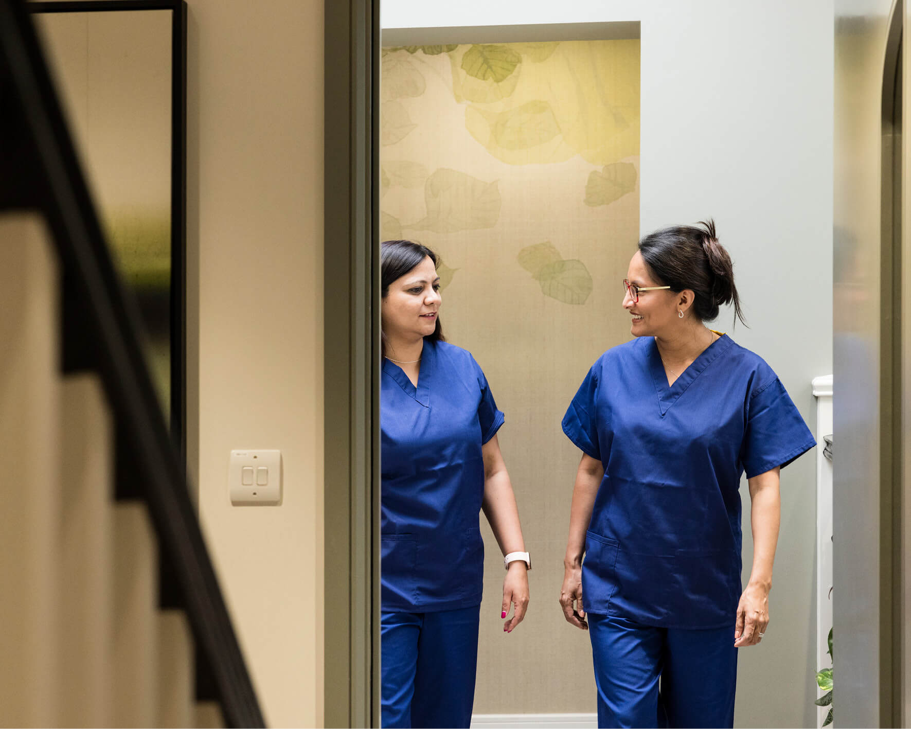 Two fertility nurses chatting and walking around the Evewell Clinic