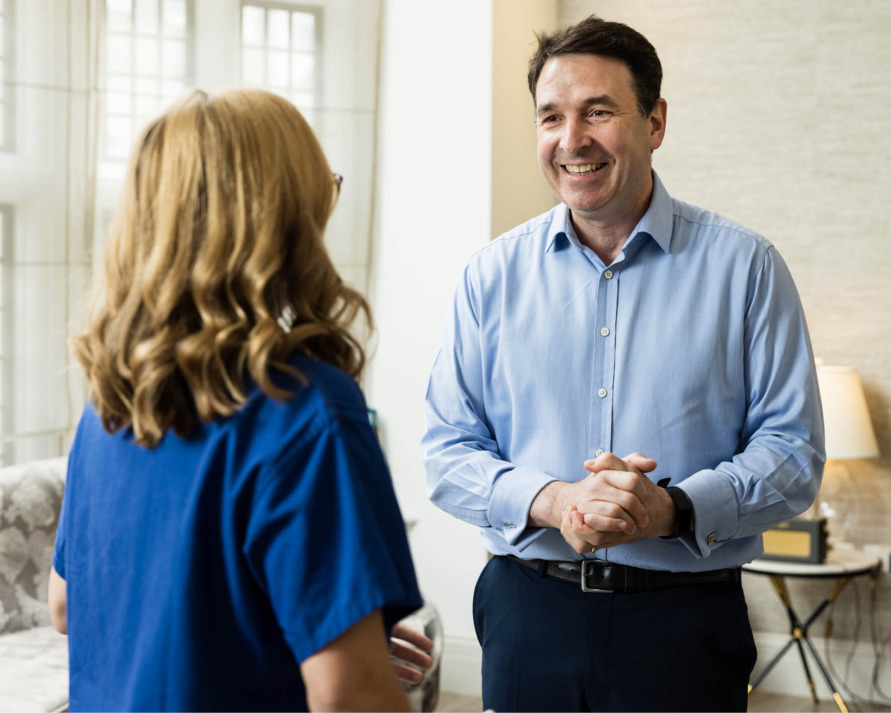 Consultant discussing male fertility with an Evewell nurse in blue srubs